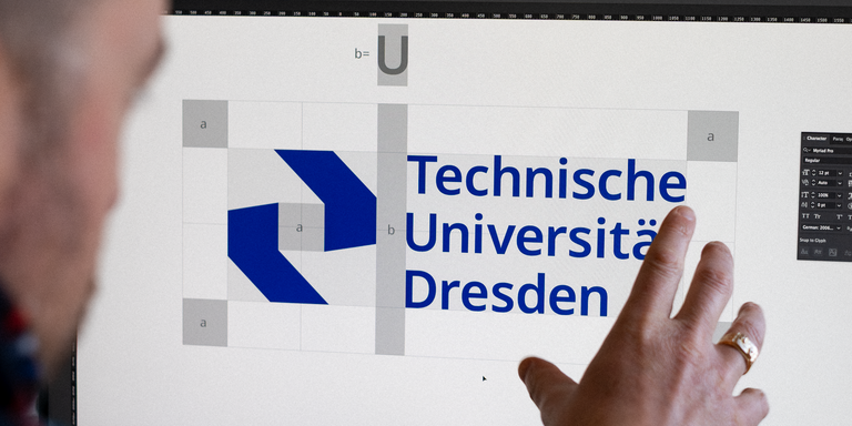 Neues Corporate Design der Technischen Universität Dresden Eine Person sitzt vor einem Bildschirm und zeigt auf das Logo der Technischen Universität Dresden